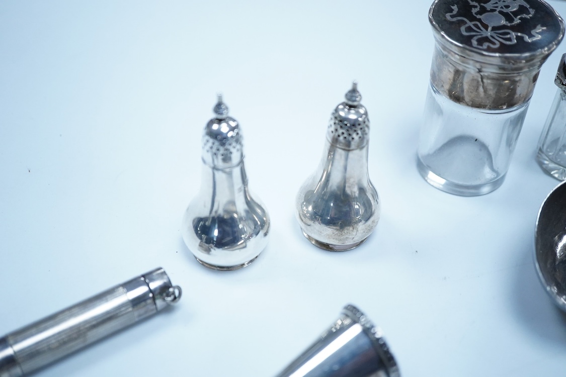 A group of assorted silver, to include a pair of modern five bar toast racks, a George V card case, a sterling vesta case, four assorted condiments, two mounted toilet bottles, mounted timepiece, a modern wooden handled